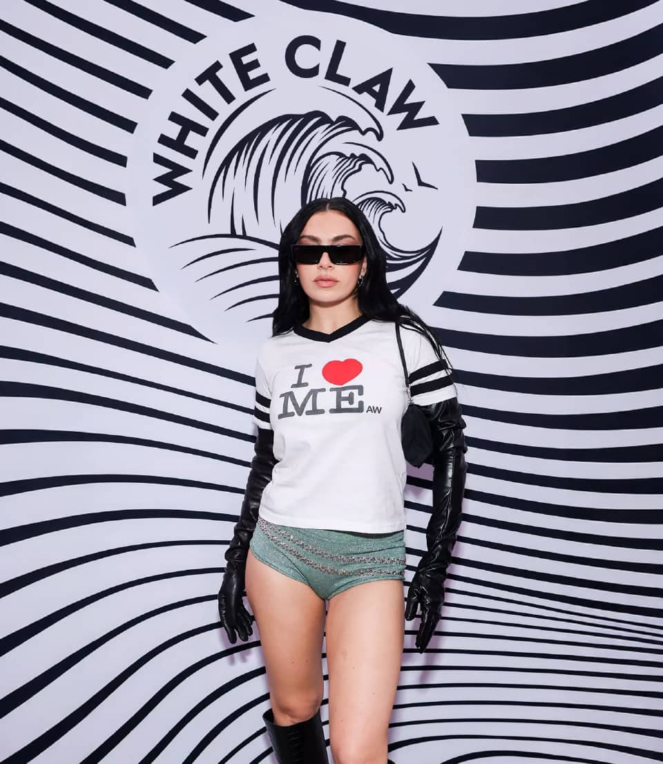 A girl standing in front of wall with White Claw branding
