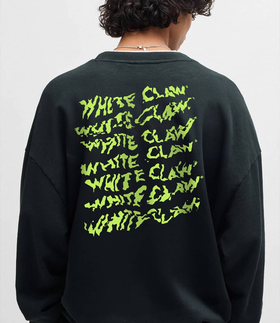 A person wearing a black jacket with green label White Claw