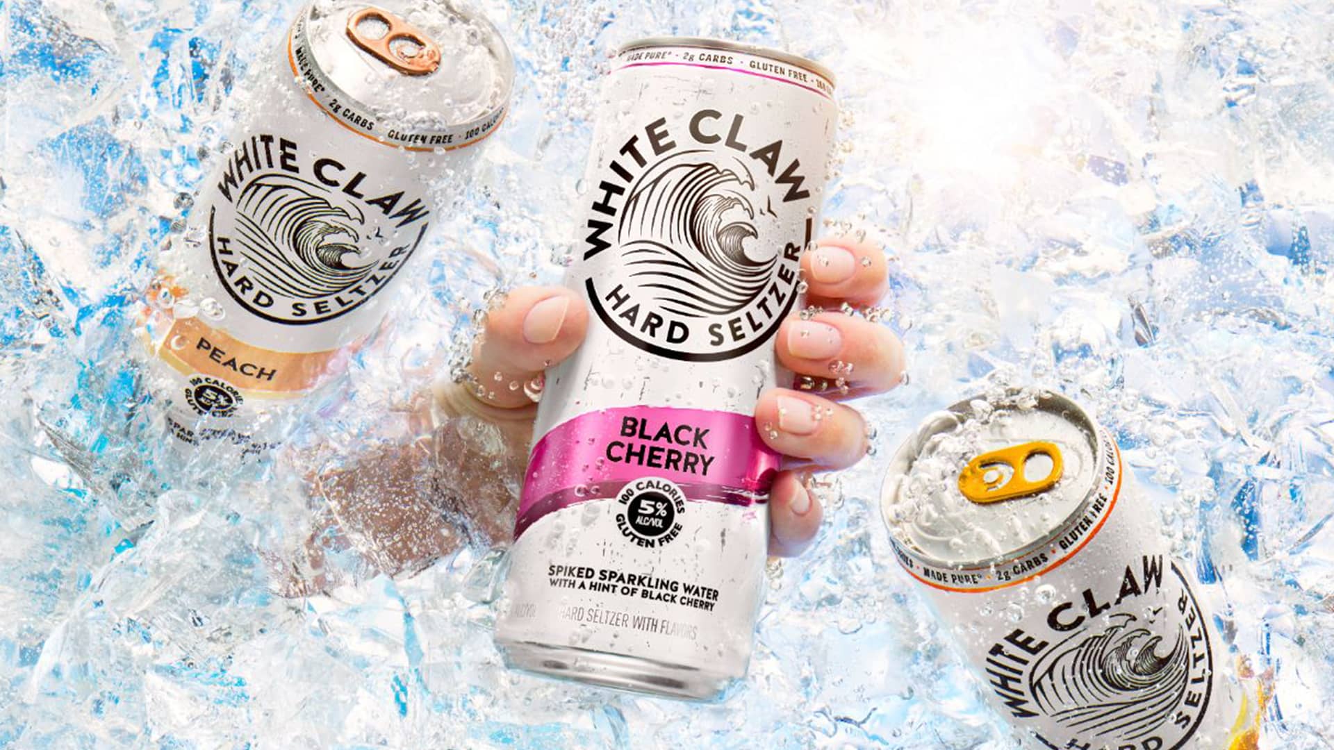 A hand holding one of three White Claw bins