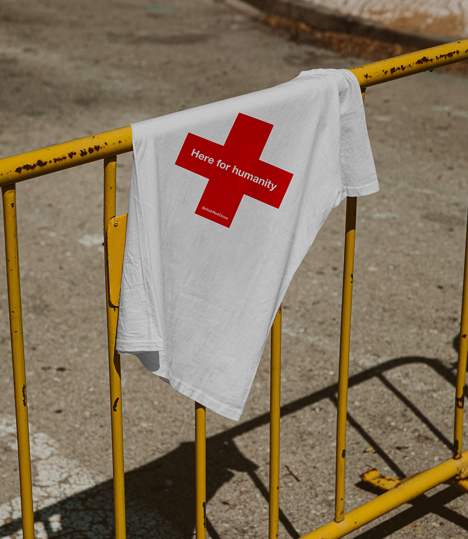 White T-shirt with red cross bended over yellow fence