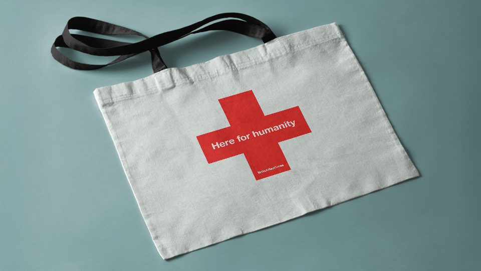 A cotton bag with red cross and label: Here for humanity