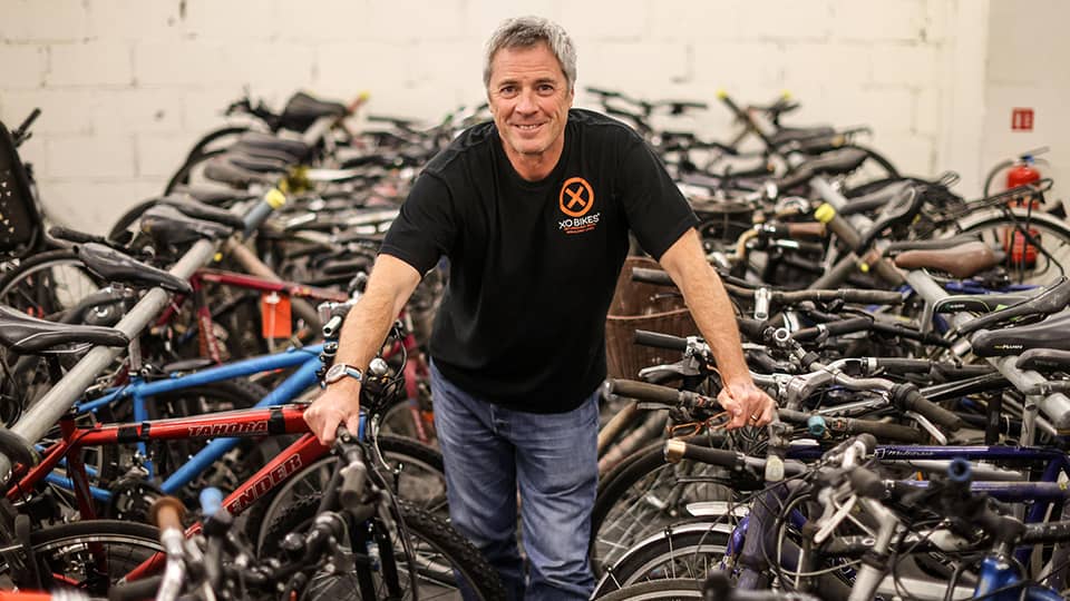 Man standing in between bikes